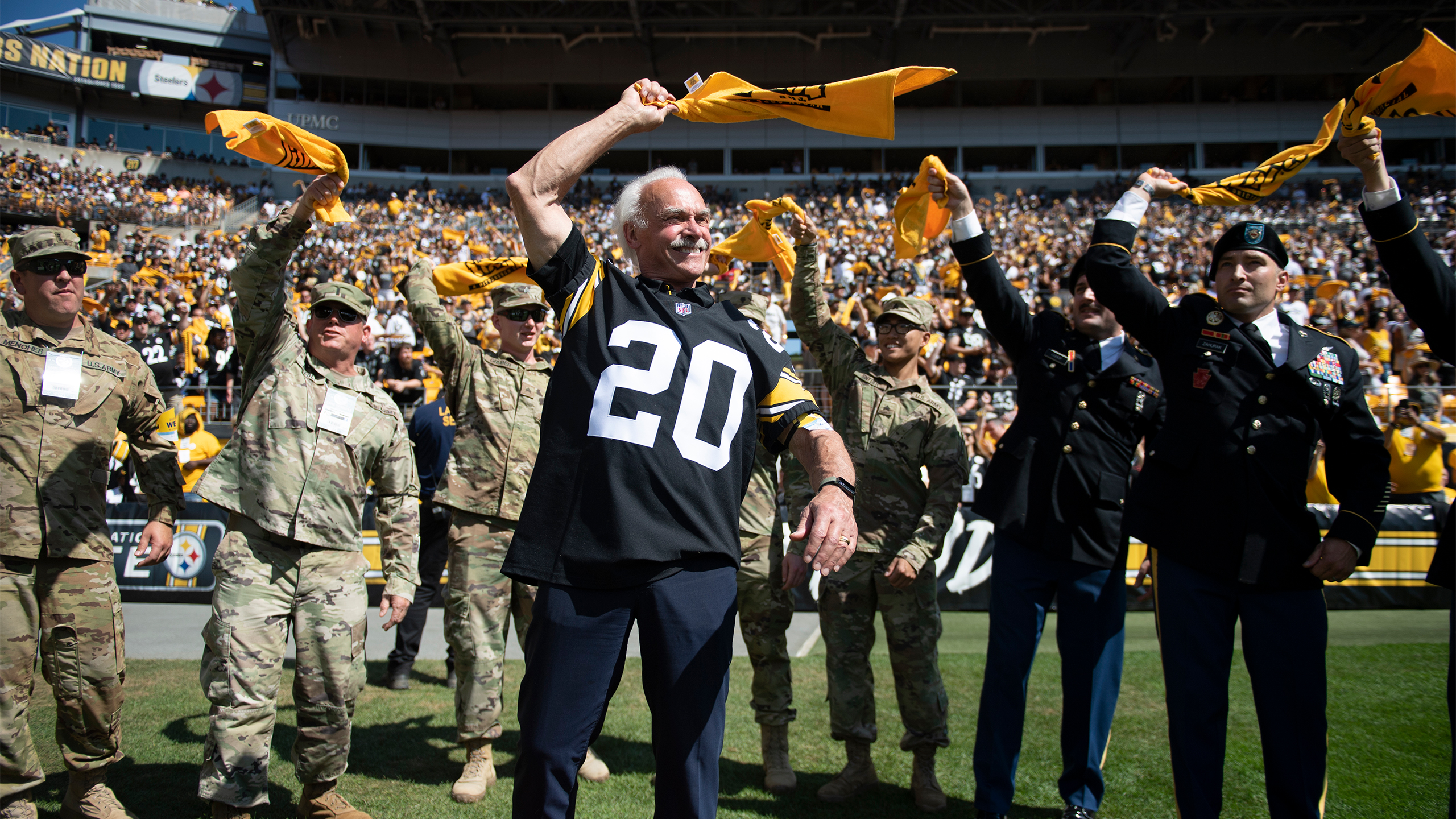 Steelers Legend Rocky Bleier leading the Terrible Towel Twirl with members of the US military